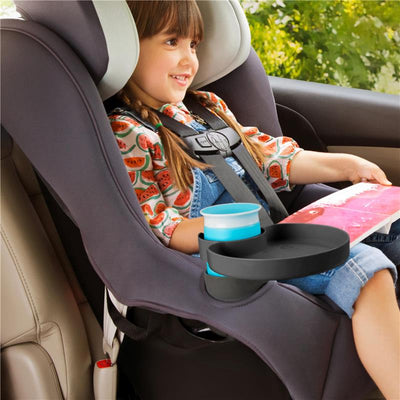 Munchkin Car Seat Tray attached to a car seat, with a girl holding a book and a drink in the tray.