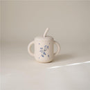 100% silicone training cup in lilac with floral design, featuring a straw and two easy-grip handles.