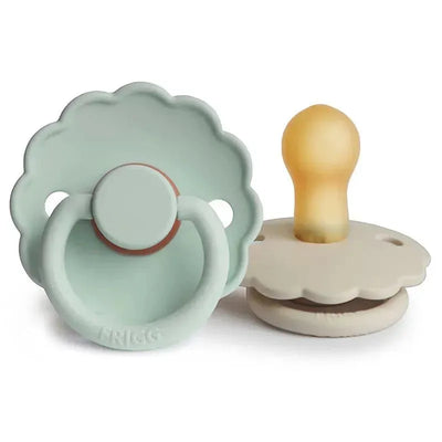 Natural rubber pacifiers in seafoam and cream colors, featuring a daisy design, suitable for infants 0-6 months.