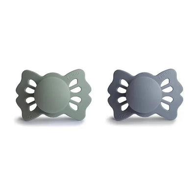 Two symmetrical silicone pacifiers in sage and great gray colors, intended for infants aged 0 to 6 months.