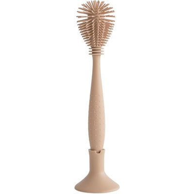 Mushie Silicone Baby Bottle Brush in a natural color, featuring a textured handle and a rounded brush head, designed for cleaning baby bottles.