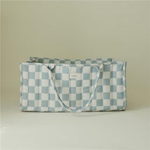 Mushie Baby Diaper Caddy in blue check pattern, designed for organizing newborn essentials, with side handles.