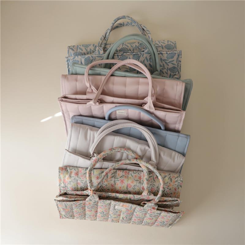 Organized stack of Mushie Baby Diaper Caddies in various pastel colors, showcasing the blush option at the front.