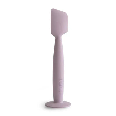 Soft lilac Mushie diaper cream applicator made of silicone, featuring a suction base for easy use.