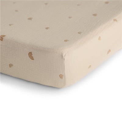 Extra soft organic muslin crib sheet with a beige color and small rainbow patterns, designed for baby cribs.