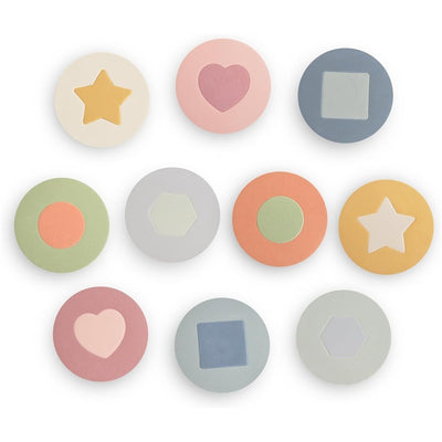 Mushie Foam Bath Puzzle features ten colorful round pieces with various shapes, including stars, hearts, and hexagons.