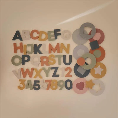 Colorful foam letters and numbers, including alphabet A-Z and numerals 0-9, mixed with various shapes.