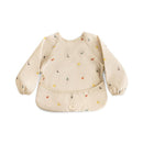 Water-resistant long sleeve baby bib featuring a playful dinosaur pattern, designed for adjustable fit.