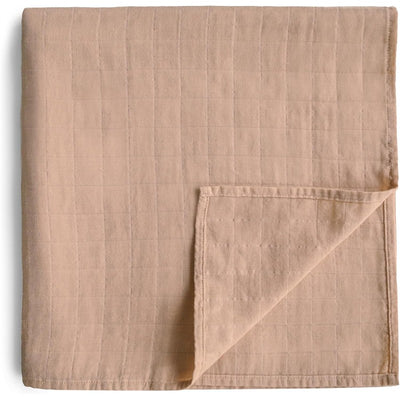 Mushie Organic Cotton Muslin Swaddle Blanket in natural color, featuring a soft, textured surface and folded corner.