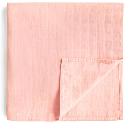 Mushie Organic Cotton Muslin Swaddle Blanket in a soft rose vanilla color, featuring a textured, quilted design.