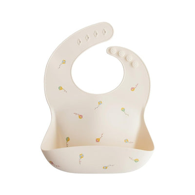 Silicone baby bib in cream color with colorful kite designs, featuring a deep pocket for catching spills.