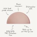 Mushie silicone placemat for kids in a soft pink color, featuring stain-resistant, dishwasher safe, and BPA-free qualities.