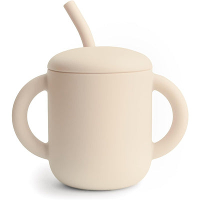 Mushie Silicone Training Cup in Shifting Sand color, featuring a lid, straw, and two easy-grip handles.