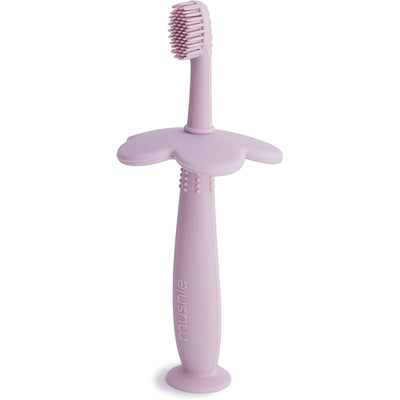 Soft lilac silicone training toothbrush with a flower-shaped handle and textured bristles for toddlers.