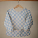 Water-resistant baby bib with adjustable long sleeves, featuring a blue and white checkered pattern.