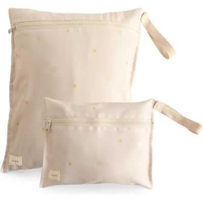 Water-resistant wet bags from Mushie, featuring a sun pattern in soft beige, with one larger and one smaller bag.