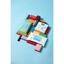 Mustela Compostable Cleansing Water Wipes package surrounded by colorful wooden blocks on a light blue background.