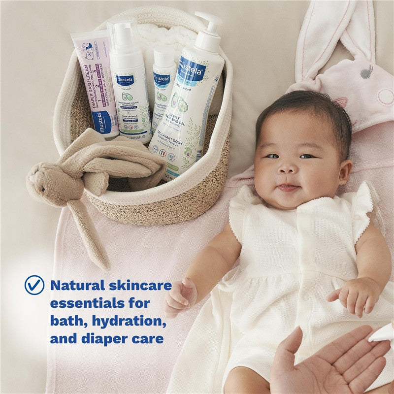 Mustela Newborn Arrival 5-Piece Gift Set featuring baby skincare products in a basket, with a smiling baby in a white outfit.