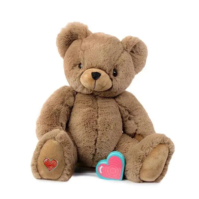 Cocoa bear plush toy with a brown fur exterior, a pink heart-shaped accessory, and a heart design on its foot.