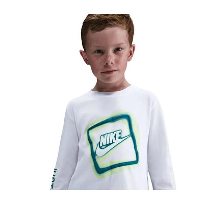 Nike kids long sleeve t-shirt in white with neon green and blue logo, worn by a boy with red hair and freckles.