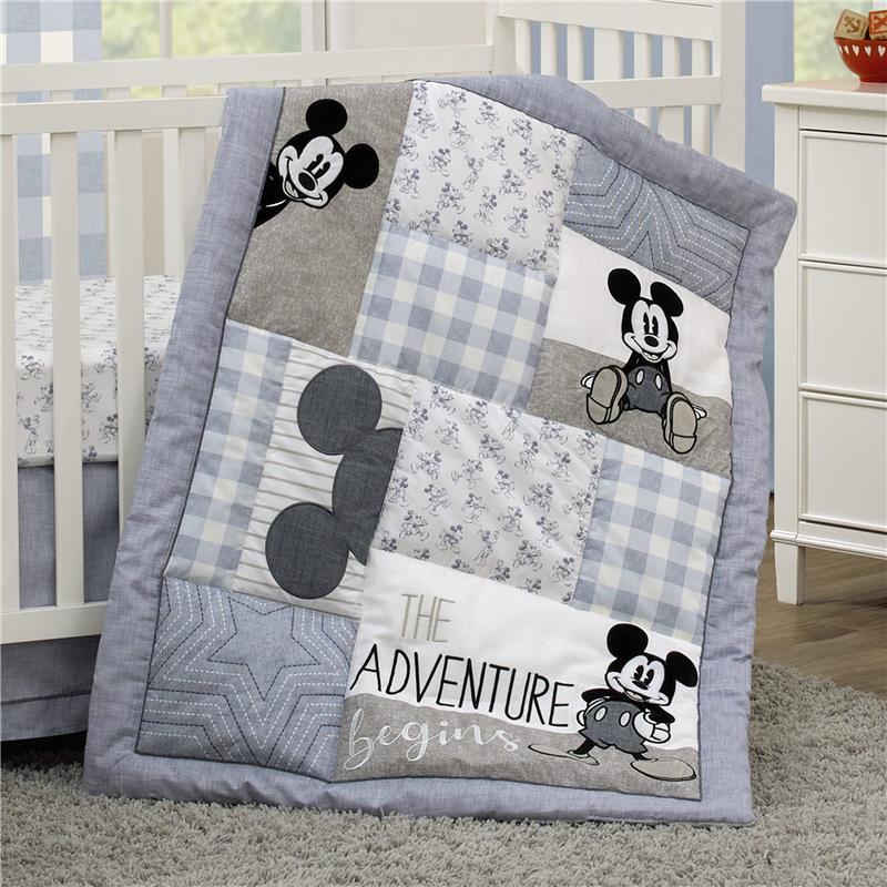 Blue Mickey Mouse blanket draped over a white crib.