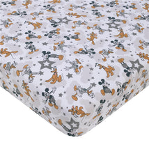 Disney Mickey Mouse patterned crib bedding set featuring playful designs of Mickey, Pluto, and stars.