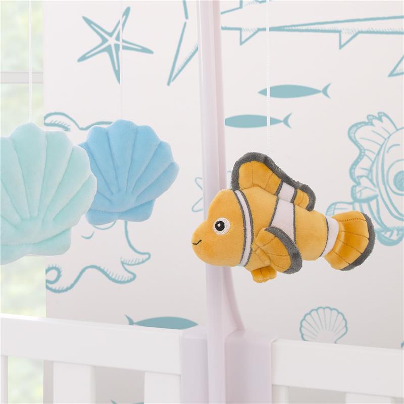 Plush Nemo toy with seashells hanging from a mobile, designed for nursery decor.
