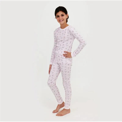 Long sleeve pajama set for girls featuring a light pink pattern of bows, model posing with a smile.