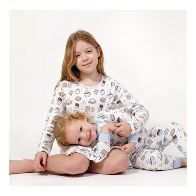 Long sleeve blue pajama set for kids, featuring playful smores and dessert patterns, worn by two smiling girls.