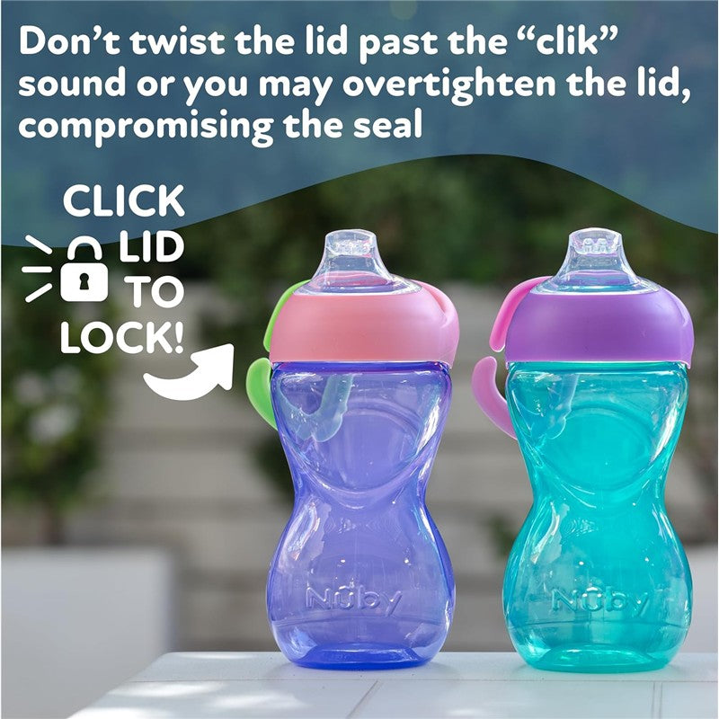 Nuby Clik-It Soft Spout Cups in pink and purple, with instructions on securing the lid by clicking, displayed outdoors.