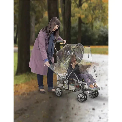 A woman in a purple coat adjusts a Nuby Deluxe Stroller Weather Shield protecting a child seated in a stroller.