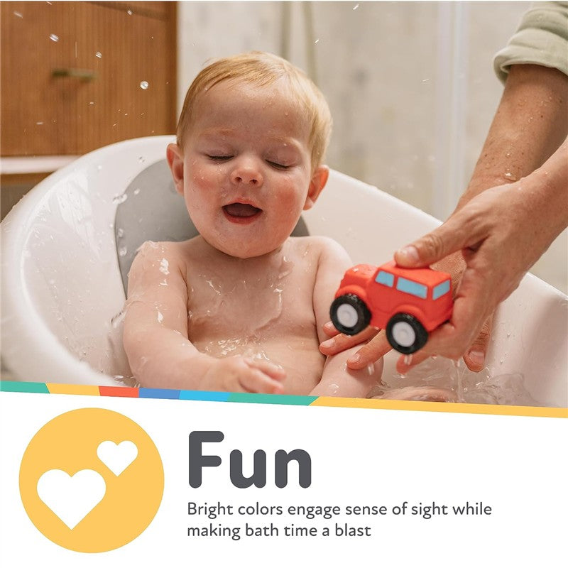 Toddler enjoying bath time, playing with a red toy car while splashing water in a white bathtub.