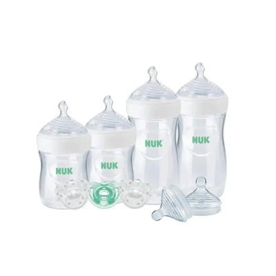 Nuk Simply Natural Bottle Gift Set featuring four bottles with clear plastic bodies and white caps, two pacifiers, and extra nipples.