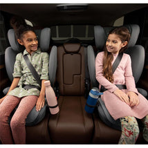 Two girls smiling in car seats with water bottles, safe travel for kids
