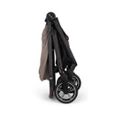 Nuna BMW Swiv stroller folded for storage, featuring a carbon fiber frame and sleek black wheels.