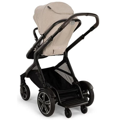 Nuna DEMI™ next stroller in Biscotti color with a black frame and large wheels, featuring a spacious seat and canopy.