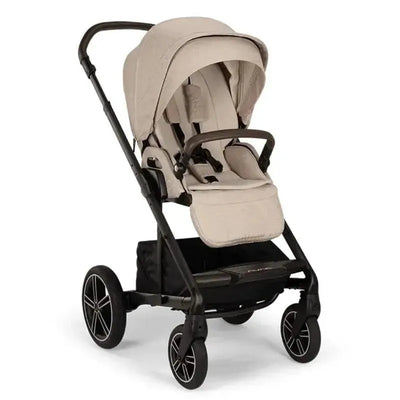 Nuna MIXX™ next stroller in Biscotti color, featuring a magnetic buckle, a padded seat, and a large storage basket.
