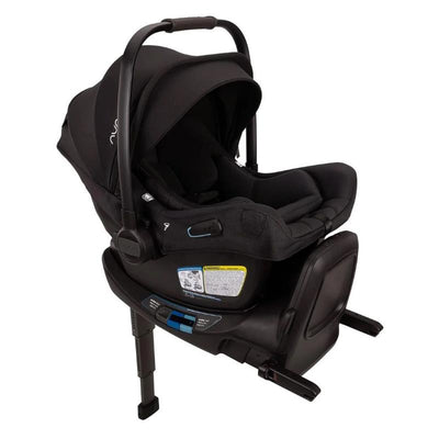 Nuna Pipa Aire Rx infant car seat in Caviar/Chocolate, featuring a removable canopy and safety labels on the base.