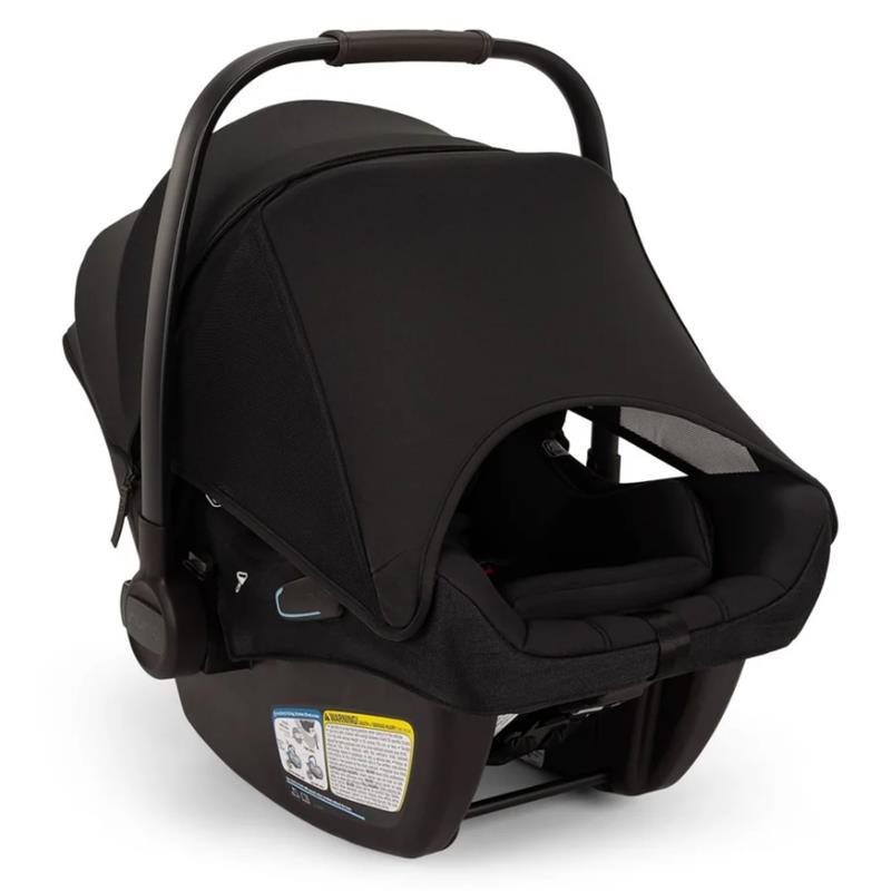 Nuna Pipa Aire Rx Infant Car Seat in Caviar/Chocolate with a black canopy and safety warning labels on the base.