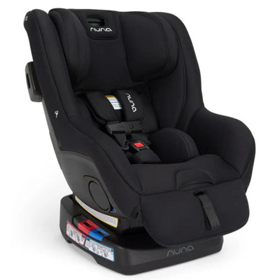 Nuna RAVA™ next Convertible Car Seat in Caviar with adjustable straps and safety labels, designed for child safety.