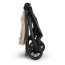 Nuna Swiv + Pipa Aire Rx travel system in Biscotti, featuring a compact, folded stroller with black wheels.