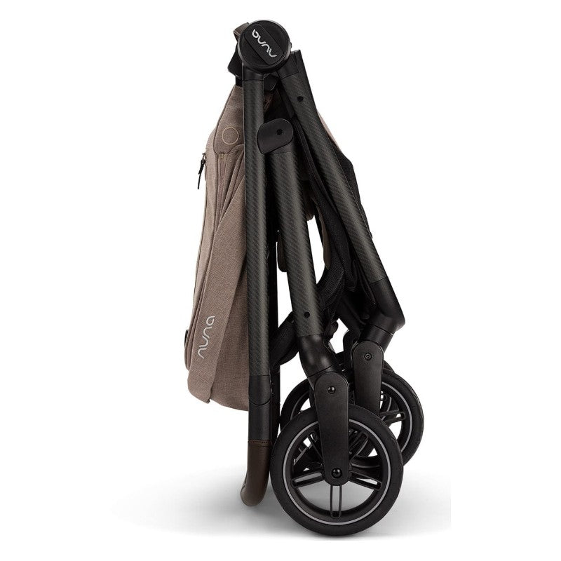 Nuna Swiv stroller folded for travel, featuring a carbon frame with brown fabric and black wheels.