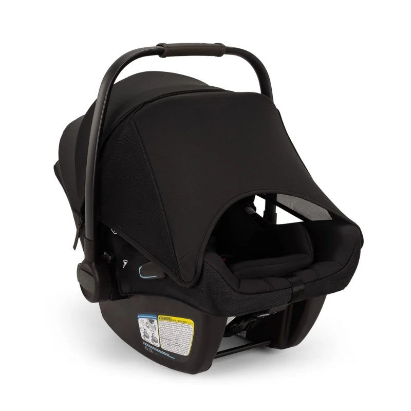 Nuna Pipa Aire Rx infant car seat in black with a protective canopy and safety labels on the base.