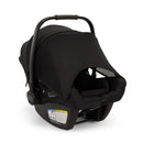 Nuna Pipa Aire Rx infant car seat in black with a protective canopy and safety labels on the base.