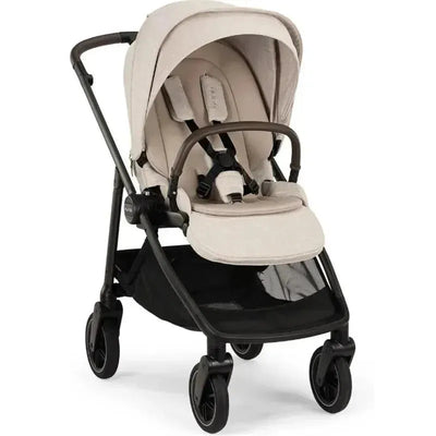 Nuna SWIV™ Stroller in Chai color, featuring a padded seat, safety harness, and large storage basket underneath.