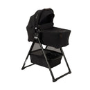 Nuna Swiv stroller with a black bassinet on a black frame, featuring a storage basket underneath.