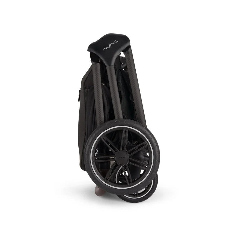 Nuna Triv Lx stroller folded with carbon fiber handles and black wheels, showcasing compact design for easy storage.