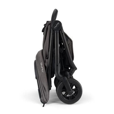 Nuna Trvl 360 Compact Stroller in Pewter, folded and showing its dark fabric and black frame with wheels.