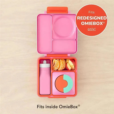 Leak-proof pink silicone water bottle beside a compartmentalized pink lunchbox with fruits and a colorful lid.