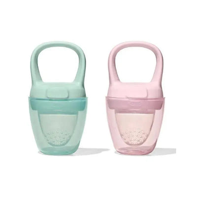 Two silicone self-feeders in opal green and blossom pink, designed for toddlers to safely enjoy snacks independently.